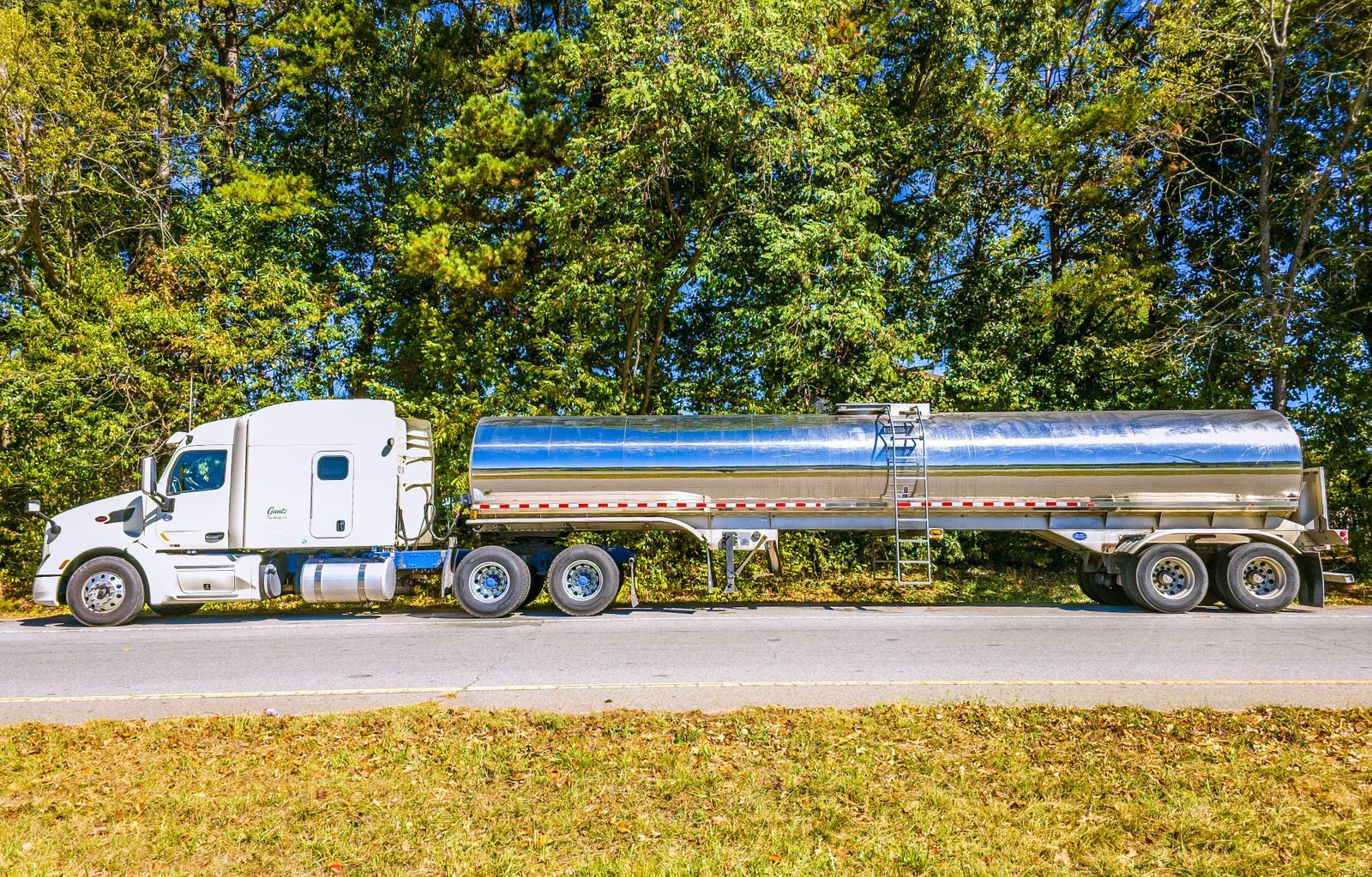 A vacuum tanker truck on a roadside, ready for septic service